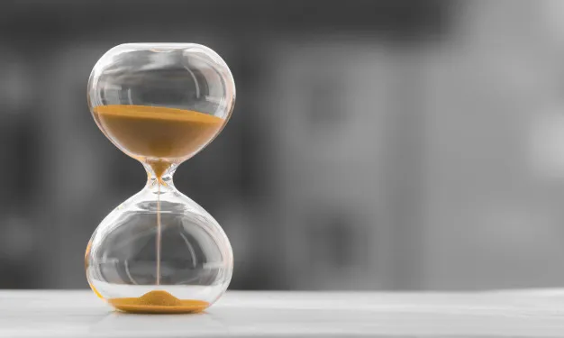 "Hourglass on a black white blurred background. time is money. Premium Photo"